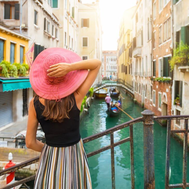 girl with hat looking at Venice canal